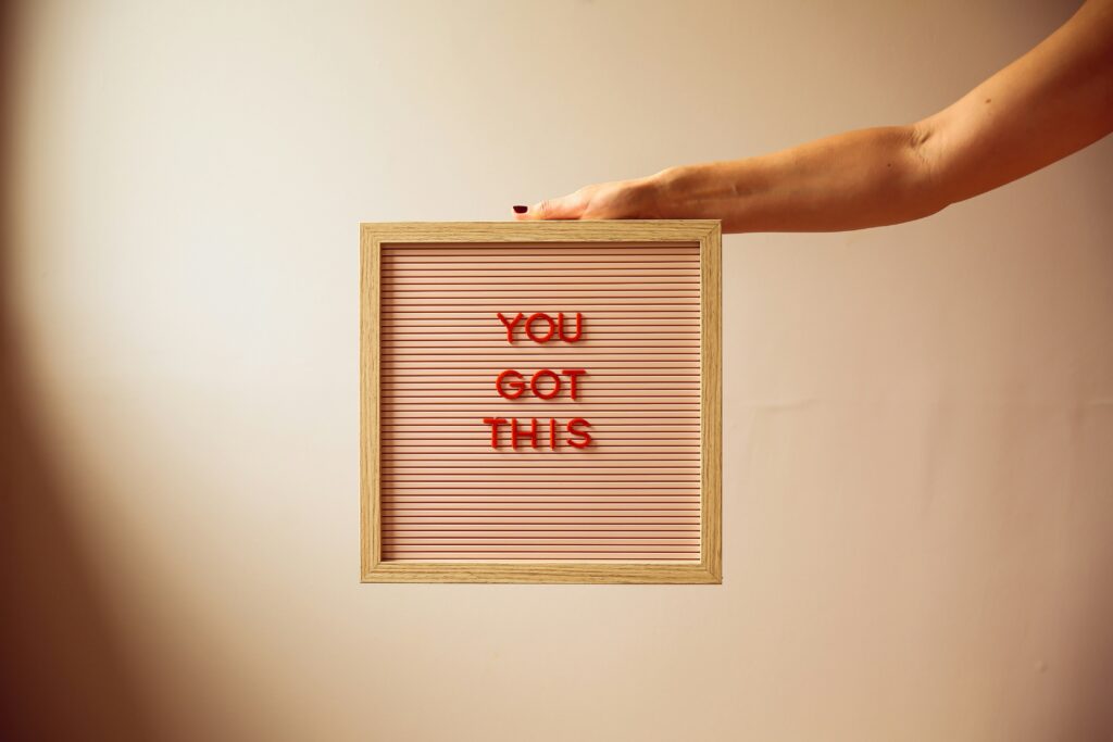 Eine Hand hält ein Schild ins Bild, auf dem "YOU GOT THIS" steht