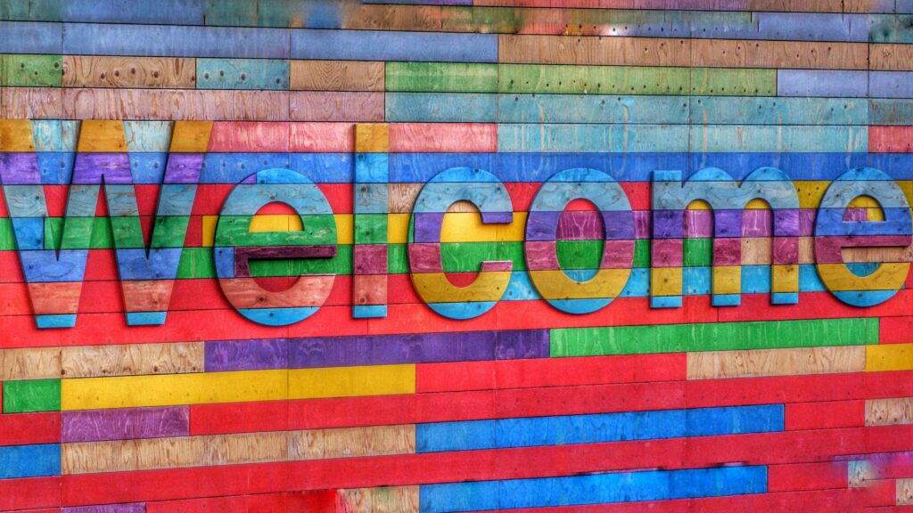 Bunte Wand auf der in großen Buchstaben Welcome steht.