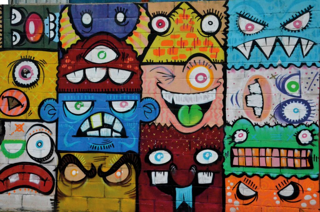 Bunte Graffiti Wand mit witzigen Gesichtern, die Grimassen ziehen