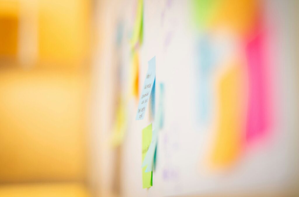 Nahaufnahme eines Post-Its der neben vielen anderen an einer Wand hängt.
