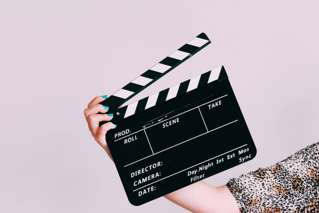Eine Hand hält eine Filmklappe fest.