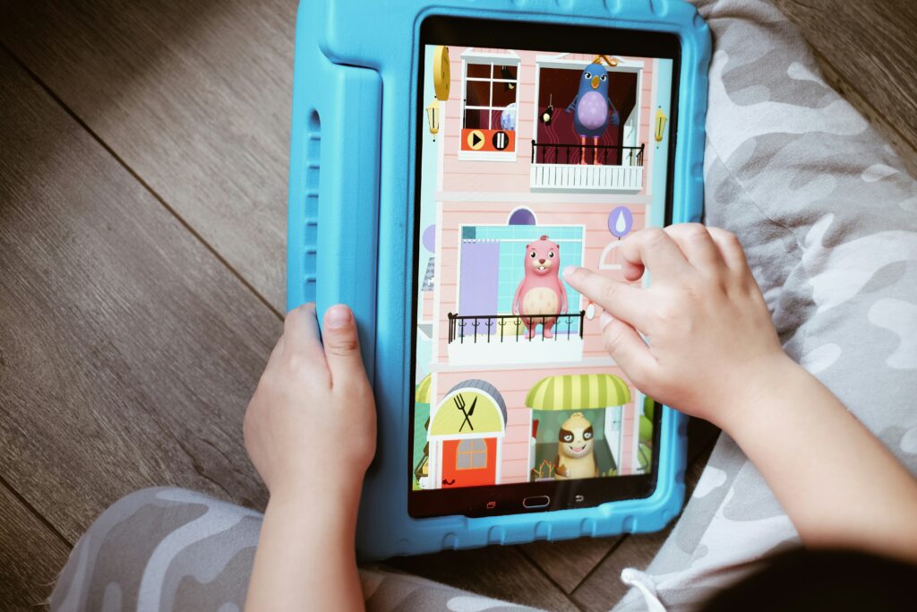 Kinderhände tippen auf einem Tablet.