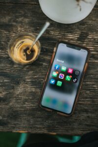 Eine Handy liegt auf einem Tisch und zeigt auf seinem Display verschiedene Social Media Apps