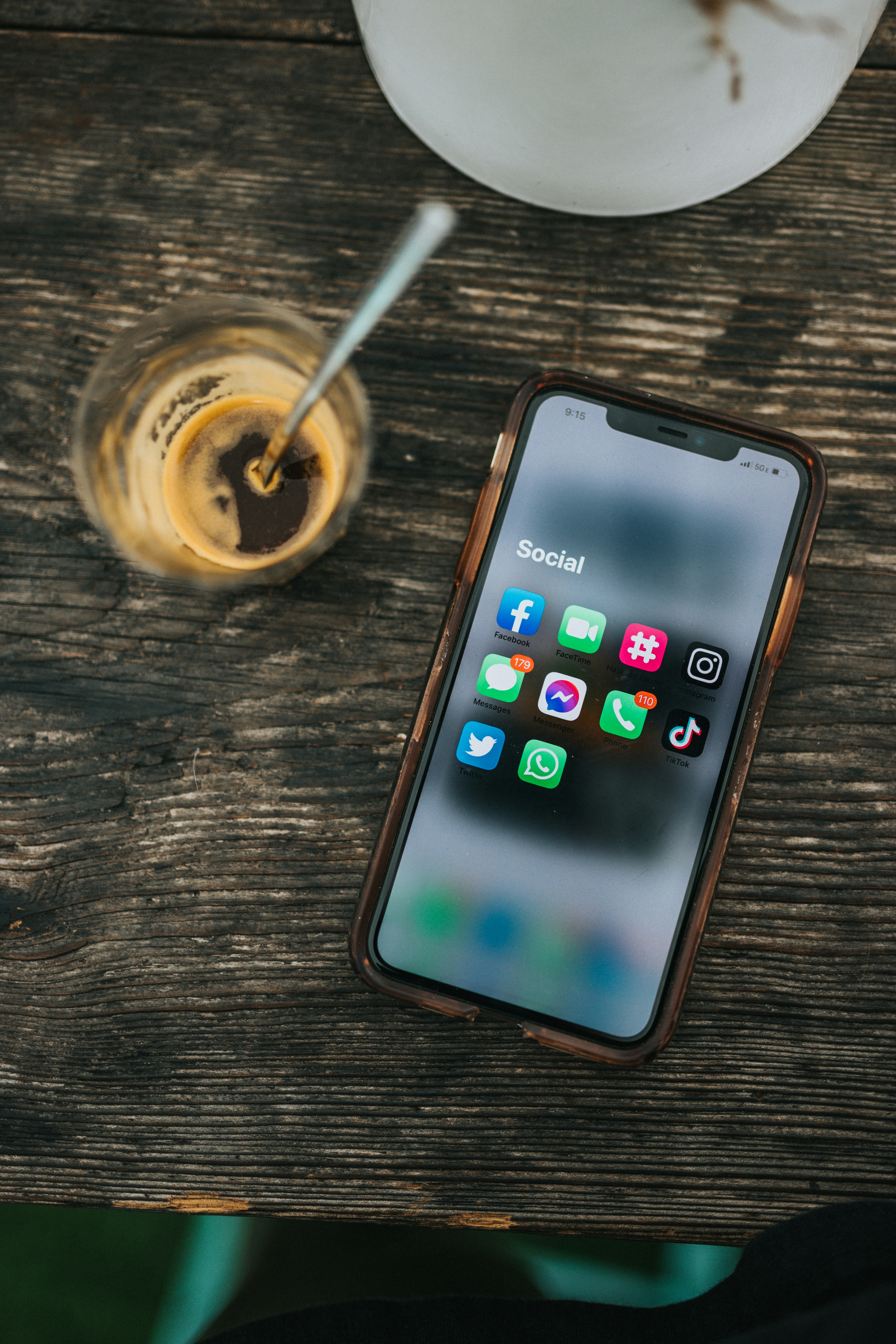 Eine Handy liegt auf einem Tisch und zeigt auf seinem Display verschiedene Social Media Apps