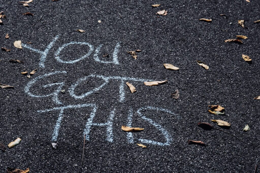 Auf dem grauen Asphalt ist mit weißer Kreide die Aufschrift zu lesen "You Got This"