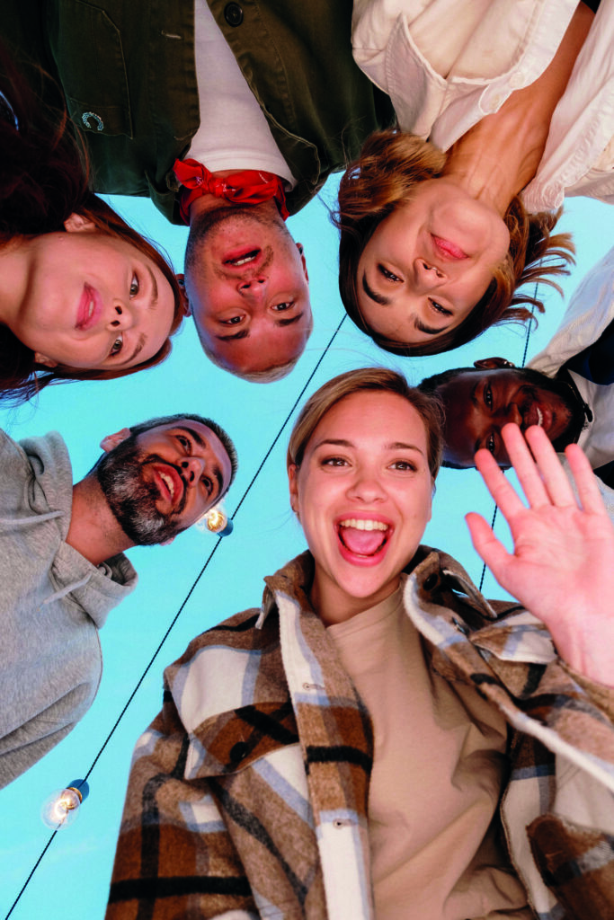 Sechs junge Erwachsene schauen lächelnd in die Kamera