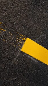 Ein gelber Farbsreifen ist auf grauem Asphalt zu sehen