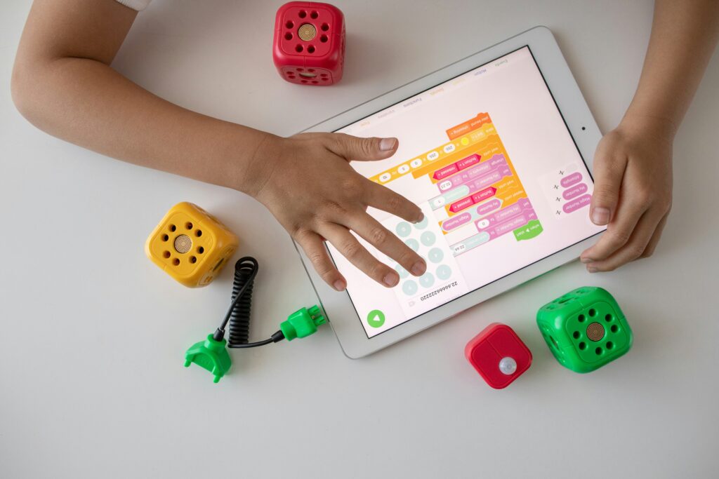 Eine kinderhand beürhrt ein Ipad und tippt darauf etwas.